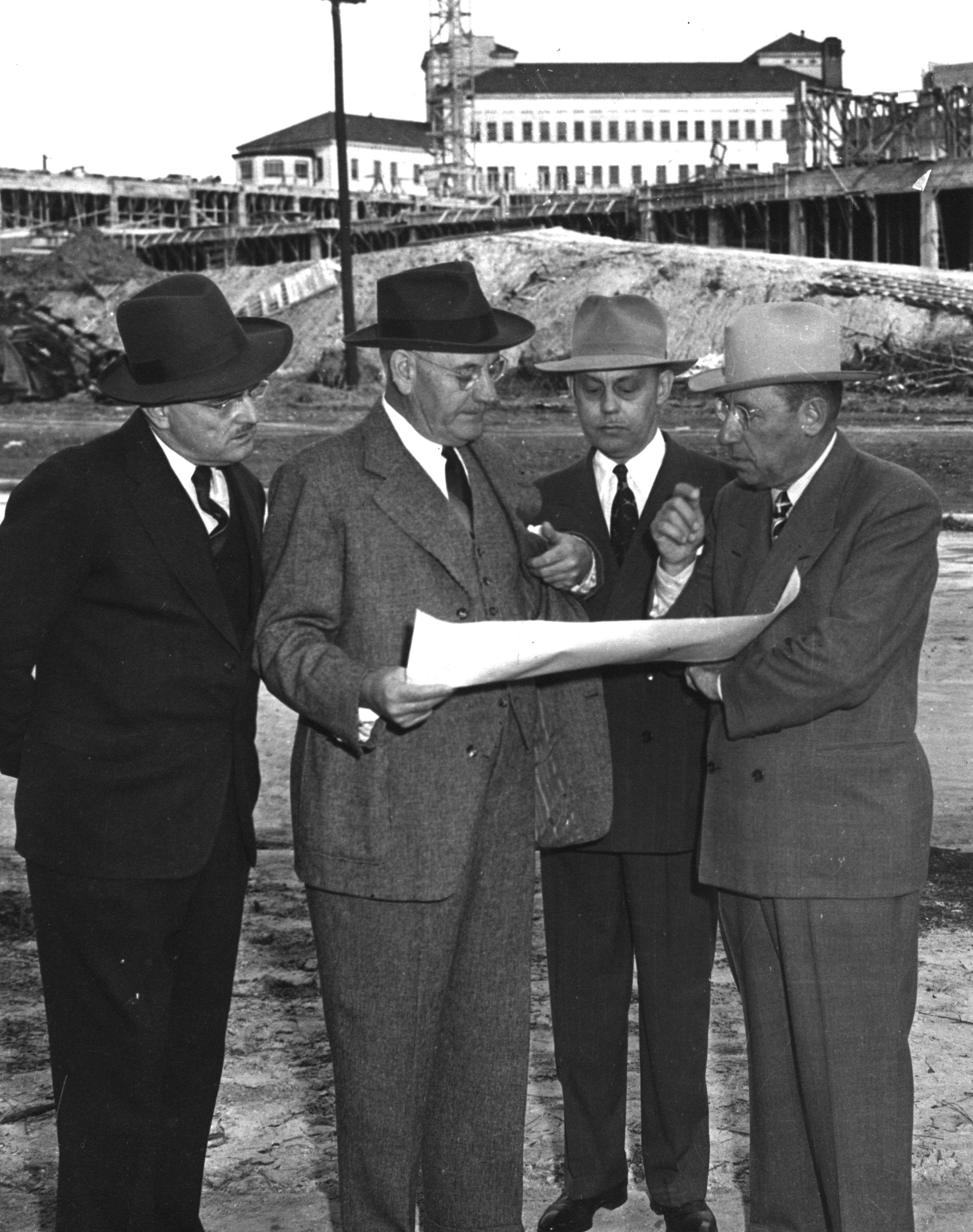 Dr. Bertner looking at plans with Texas Children's Foundation trustees, c. 1948. Hermann Hospital in the background. [E. W. Bertner, MS002, McGovern Historical Center]