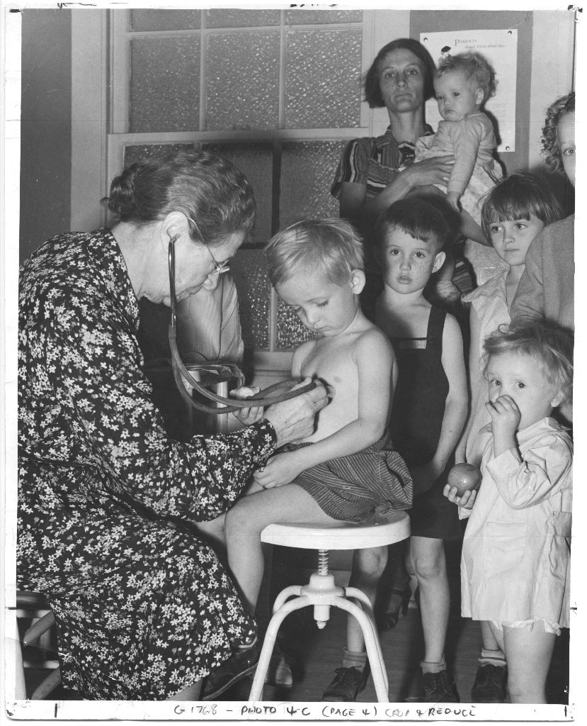 Dr. Elva A. Wright, founder of the Houston Anti-Tuberculosis League, examining children, c. 1930s. [IC 034 San Jacinto Lung Association records, Box 5, P-736, McGovern Historical Center, Texas Medical Center Library.]