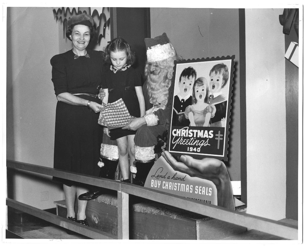 Christmas Seal campaign of 1940. Description reads, "Little Miss Christmas Seal presents seals for 1940 to Santa Clause." [IC 034 San Jacinto Lung Association records, Box 5, P-821, McGovern Historical Center, Texas Medical Center Library.]