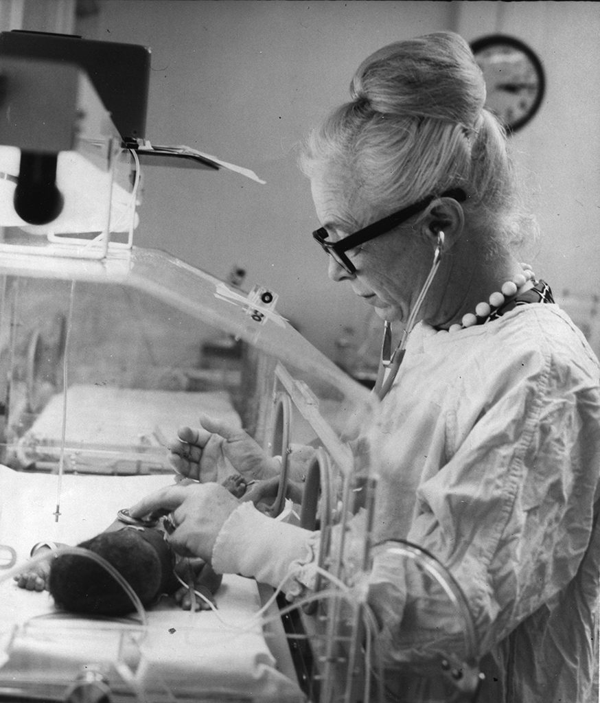 Photograph of Dr. Murdina Desmond examines newborn at Baylor College of Medicine, 1971.