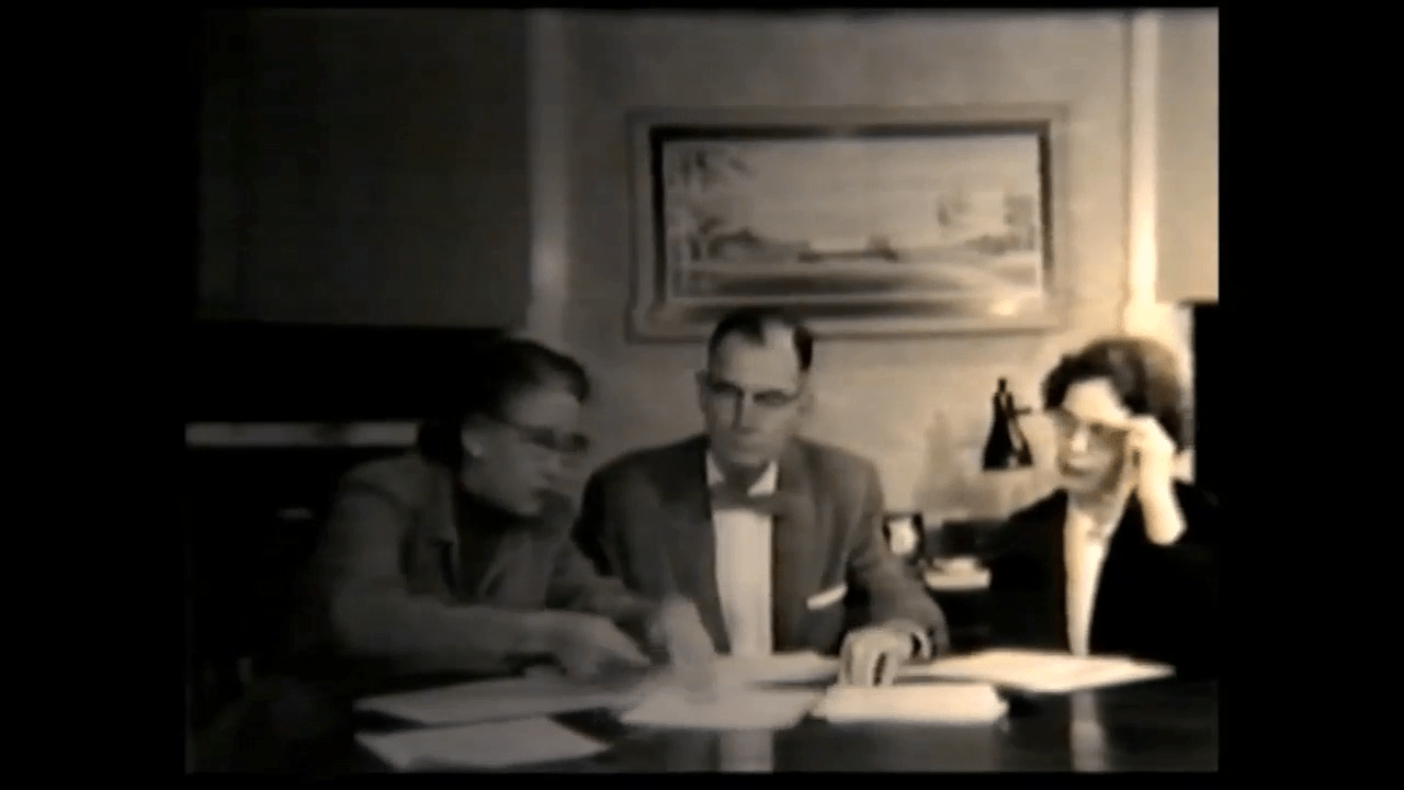 Mental health professionals going over patient information. [Screenshot from "Help Wanted" (1958), AVF.MS238.001, MS 238 Films on Mental Health provided by Bill Schnapp, McGovern Historical Center, Texas Medical Center Library]